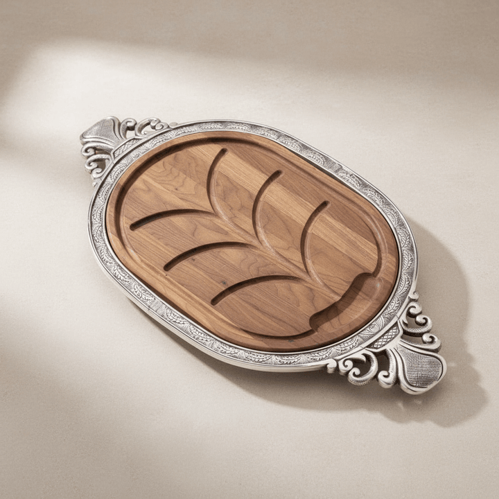 Wooden serving board with silver decorative edge on a beige background