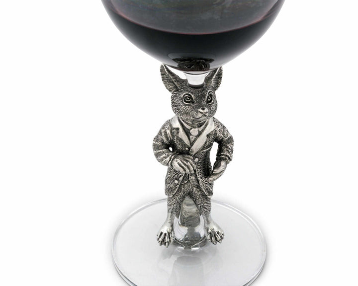 Silver fox figurine on a wine glass with red wine.