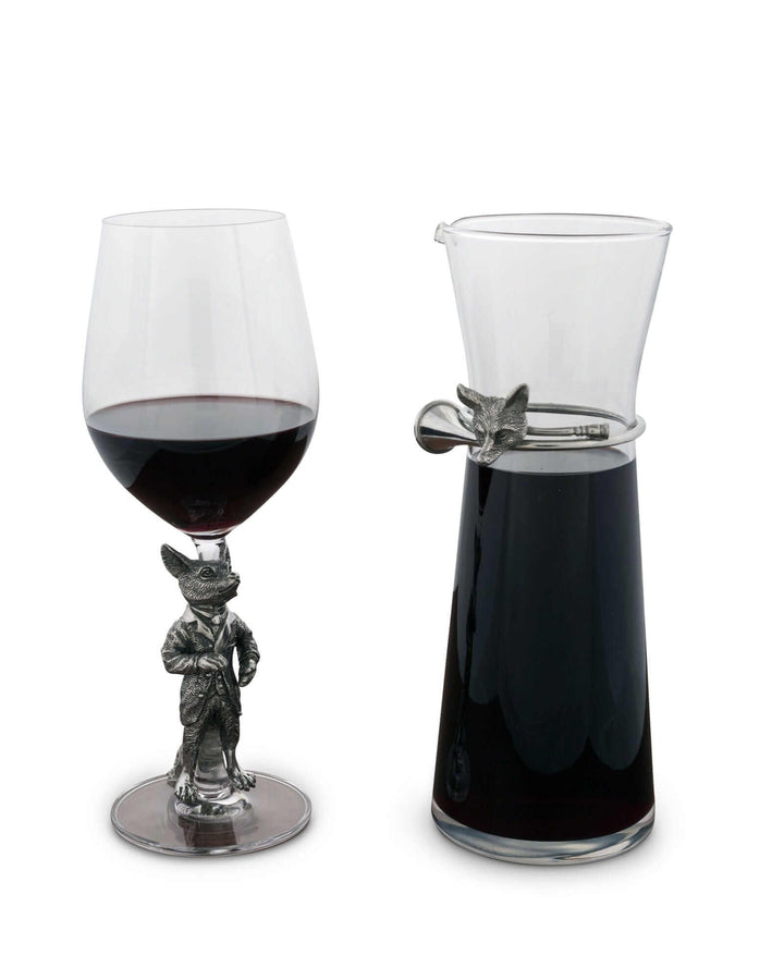 Wine glass and carafe with a decorative fox figure on a white background