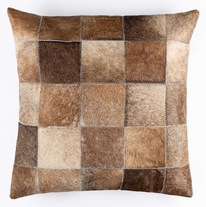 Patchwork pillow with brown and beige fur squares on a white background