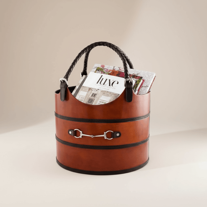 Brown leather basket with a magazine on a beige background