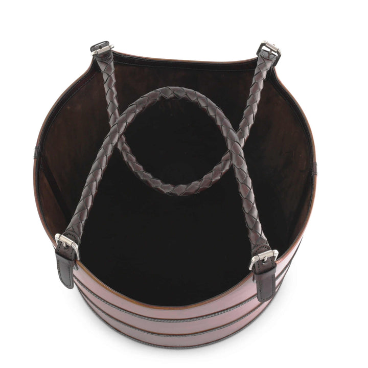 Round leather basket with braided handle on a white background