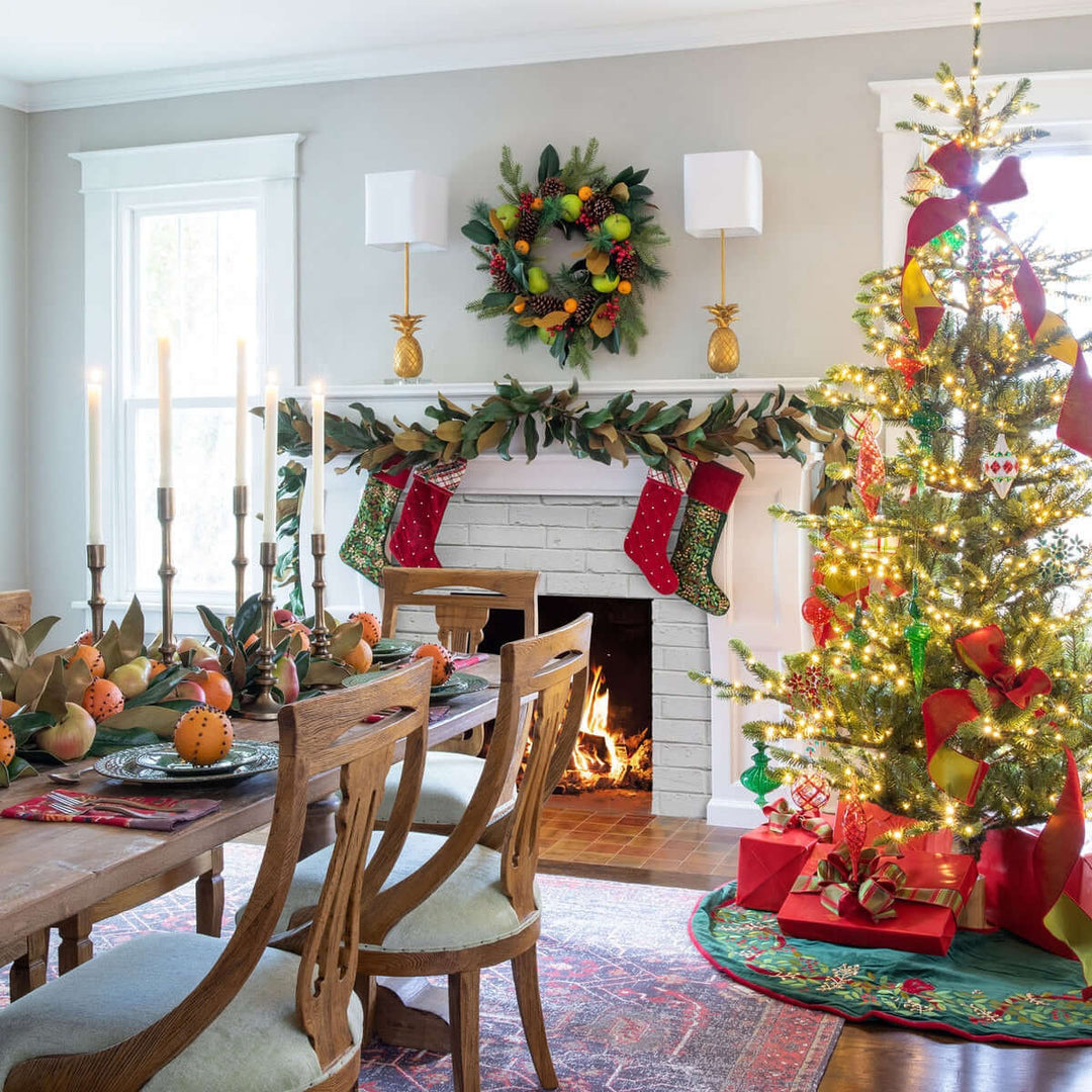 Decorated Christmas living room with a tree, stockings, and fireplace.