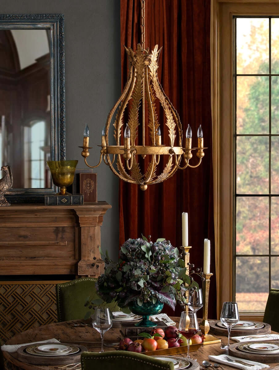 Decorative chandelier hanging above a table set for dinner with autumn-themed decor.