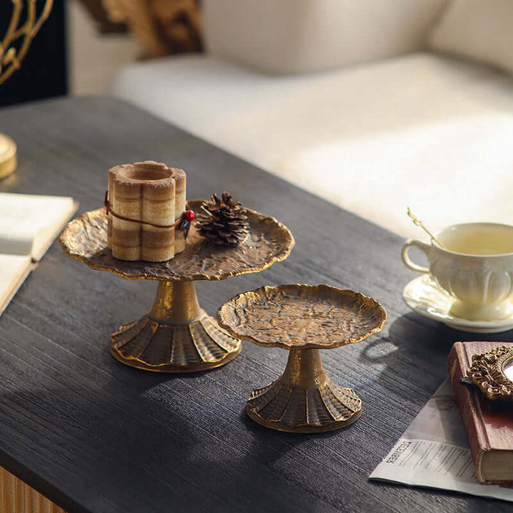 Decorative metal stands on a table with a cup and saucer in the background