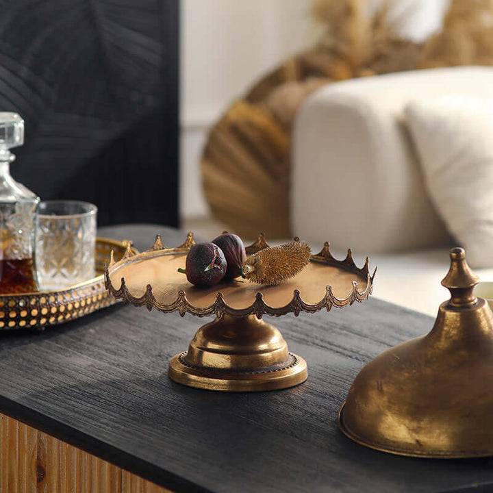 Decorative metal cloche with fruits on a wooden surface, blurred background