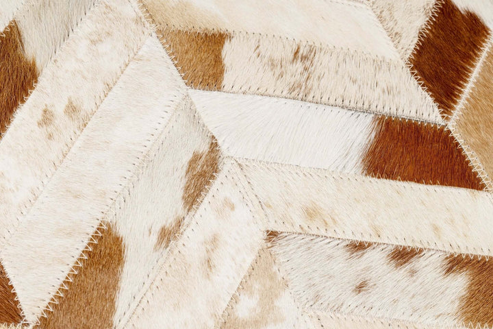 Close-up of a patterned cowhide pillow with brown and beige colors.