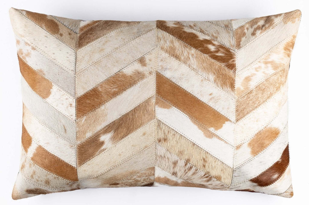 Cowhide patterned pillow with a chevron design on a white background