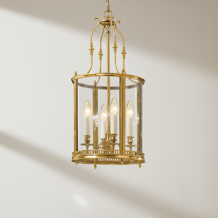 Brass chandelier fixture with glass panels on a neutral background