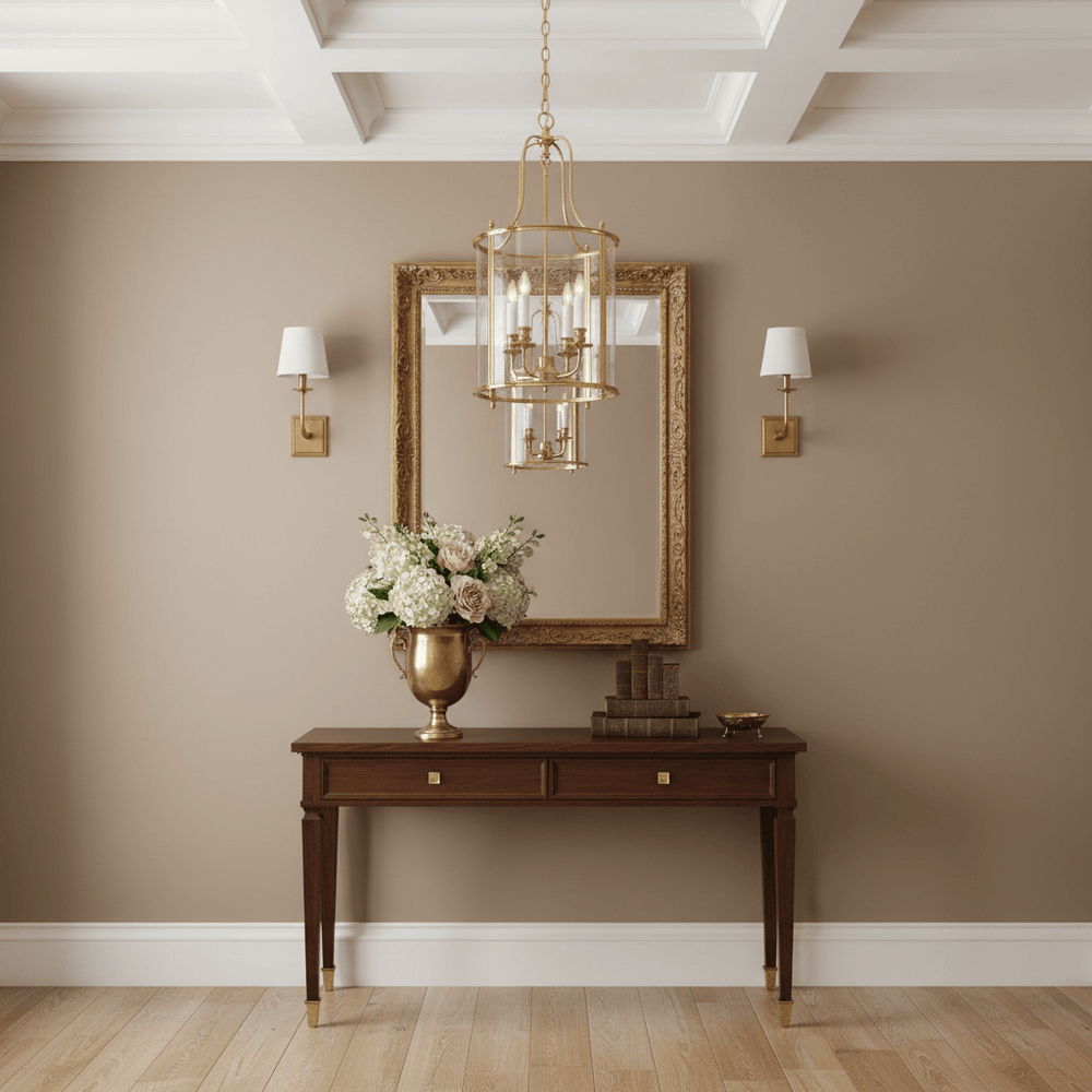 Decorative interior with brass chandelier hanging over a wooden console table, mirror, and floral arrangement.