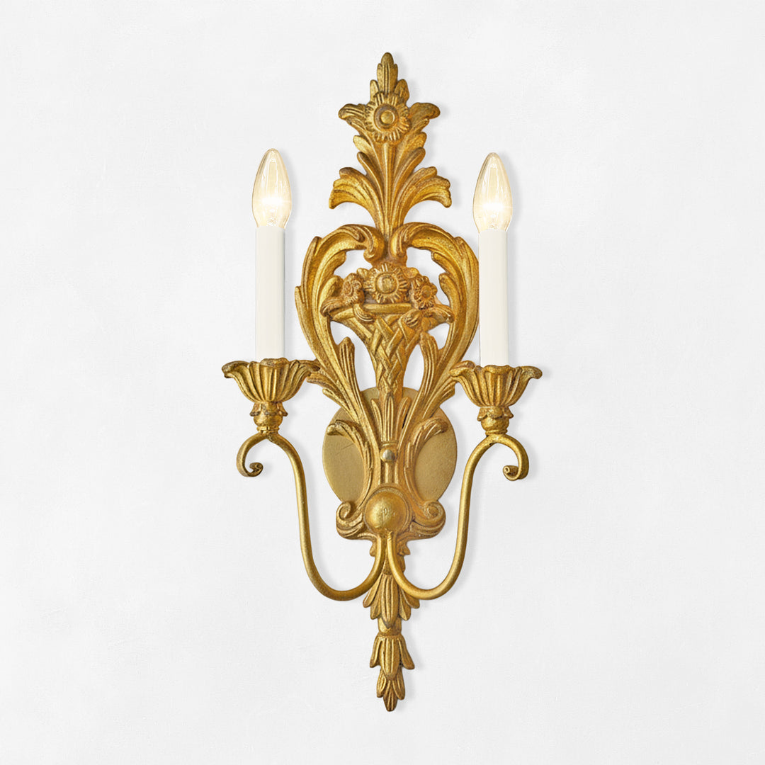 Decorative gold wall sconce with two candles on a white background