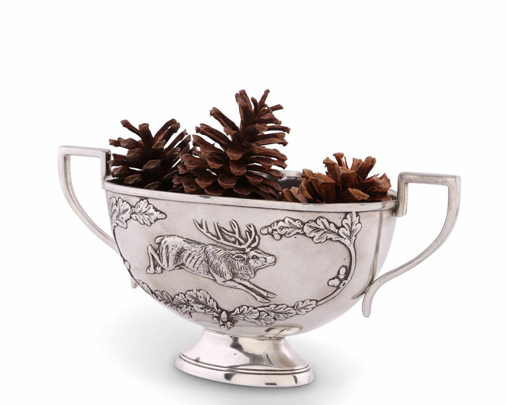 Silver bowl with engraved deer design and pine cones on a white background