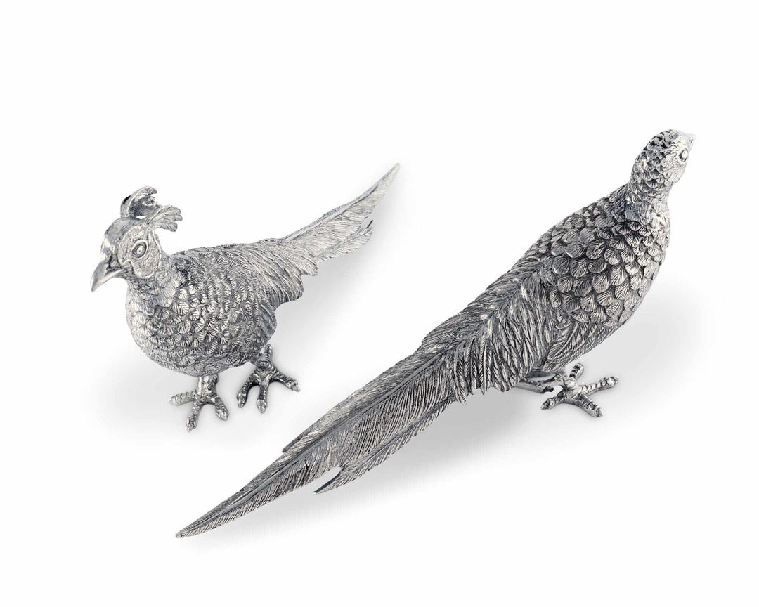 Two silver pheasant figurines on a white background