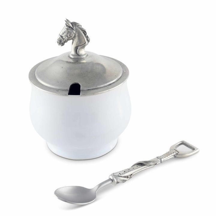White container with silver horse head lid and matching spoon on a white background