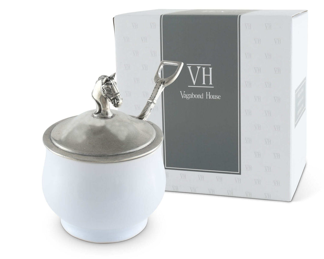 White container with silver lid featuring a horse design, next to a box with 'Vagabond House' branding.