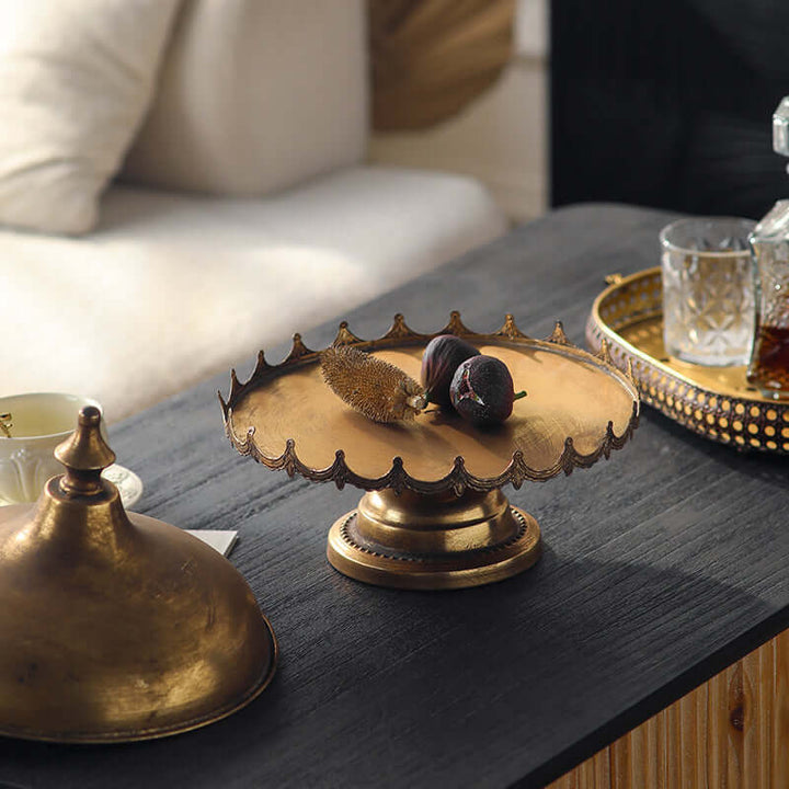 Decorative metal cloche  with fruits on a dark surface, with a blurred background