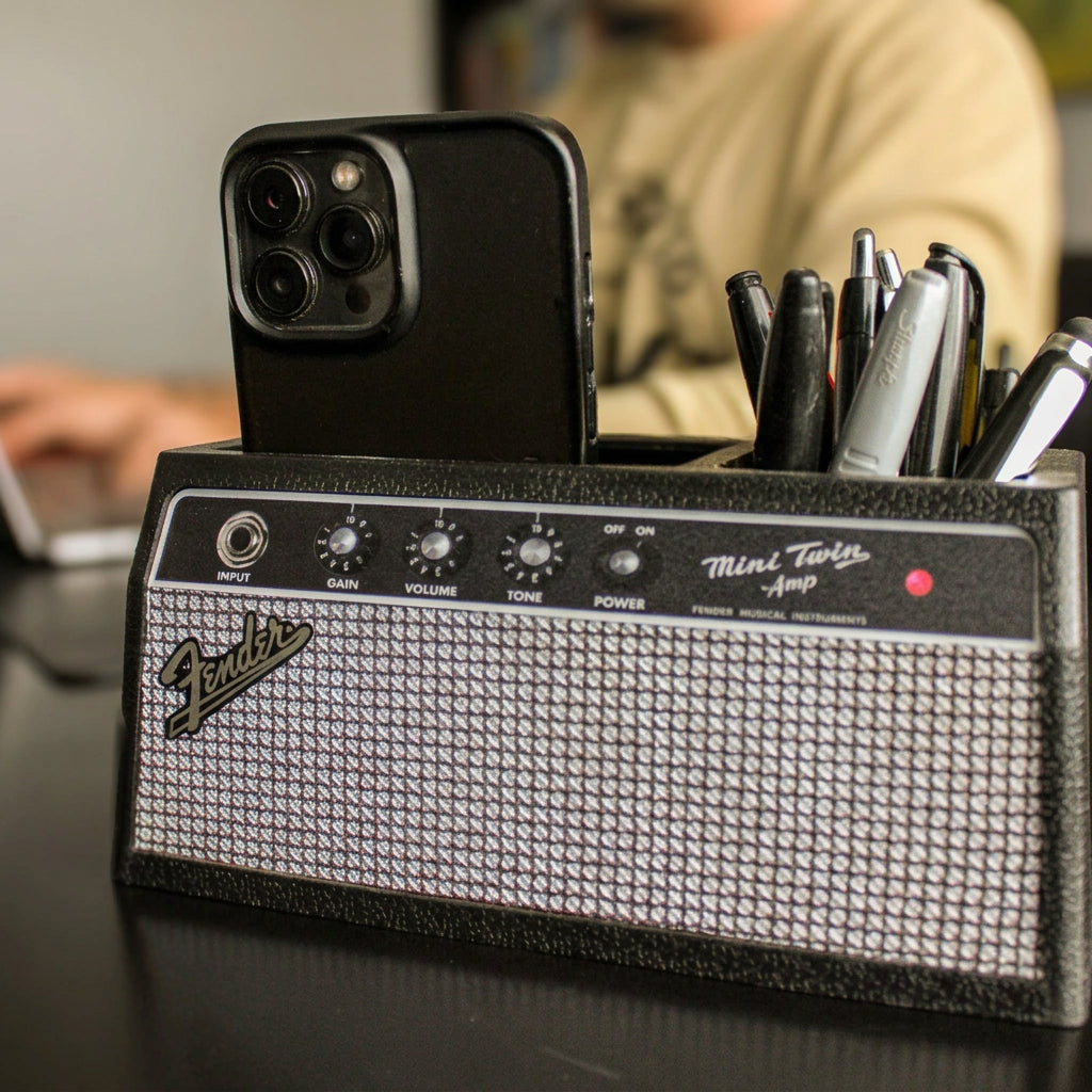Fender amplifier-style desk organizer with phone and pens on a desk