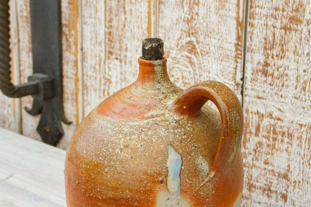 Vintage ceramic jug with a handle against a wooden background