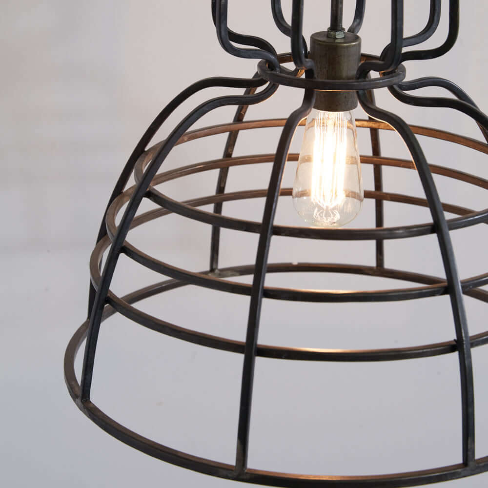 Industrial cage pendant light close-up showcasing vintage bulb and sturdy metal design. Perfect for modern rustic decor.