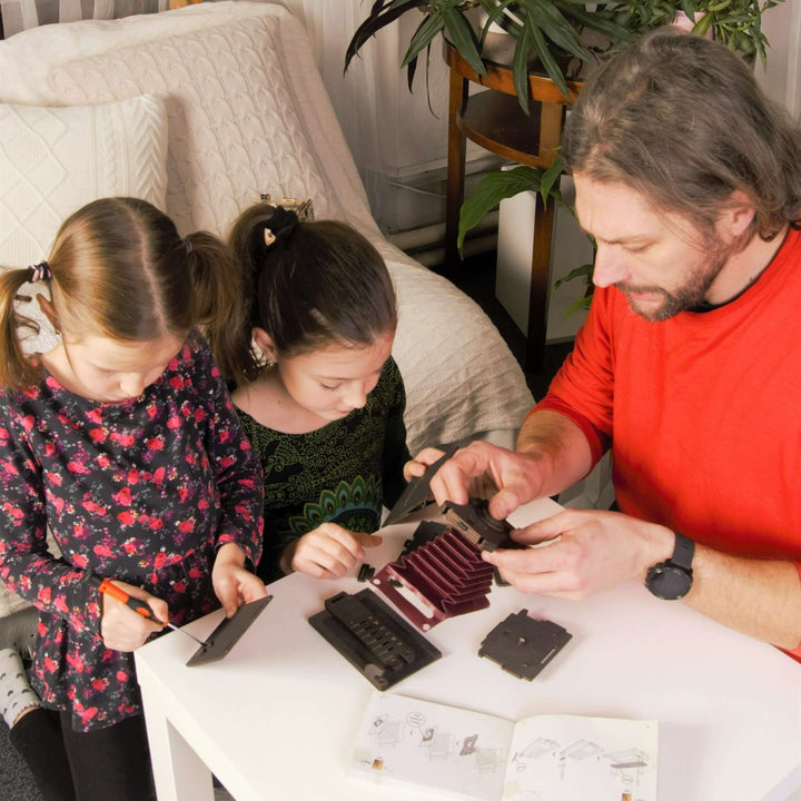 Family assembling Pinhole Square Instant Film Camera DIY Kit at home, engaging in a vintage-inspired photography project together.