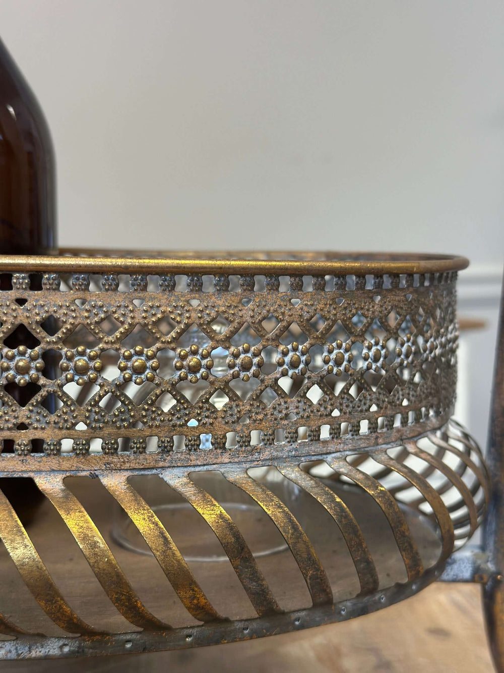 Close-up of ornate detailing on vintage brass bar cart with intricate metal design, capturing elegance and luxury.