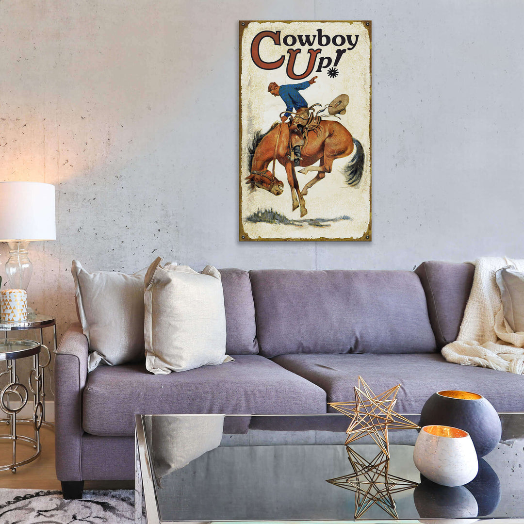 Living room with a gray sofa, decorative pillows, and a 'Cowboy Up!' poster on the wall.