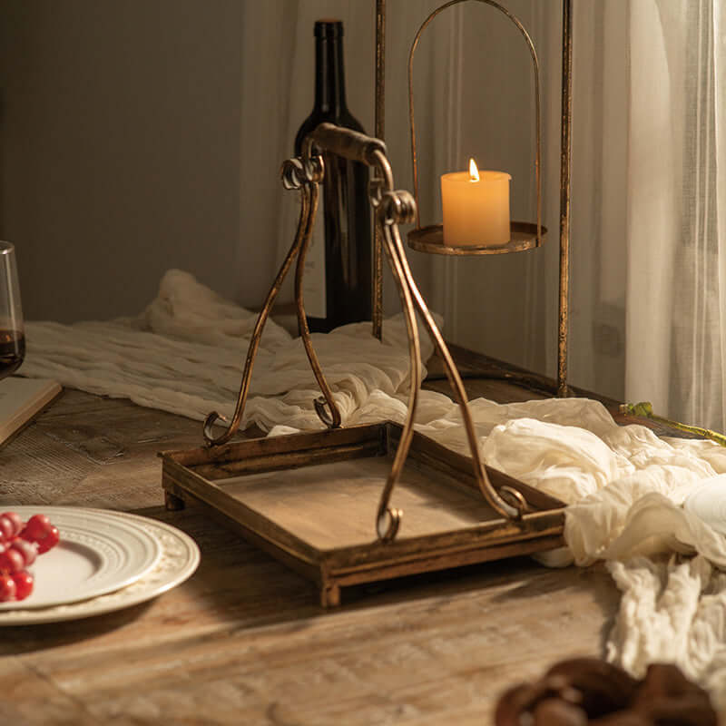 Antique gold metal serving tray on a rustic table with candlelight, evoking vintage elegance and old-world charm.