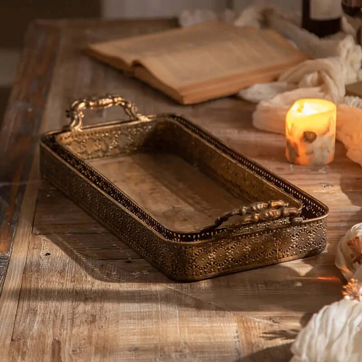 Antique Brass Filigree Serving Tray Set on wooden table with lit candle and open book, showcasing intricate craftsmanship and vintage charm.
