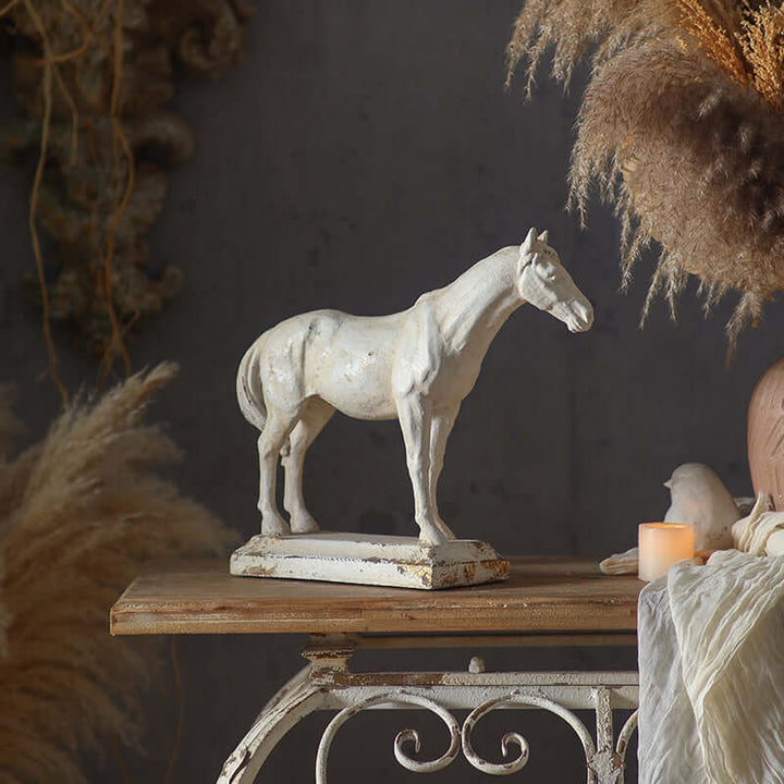 White horse statue on a wooden table with decorative elements