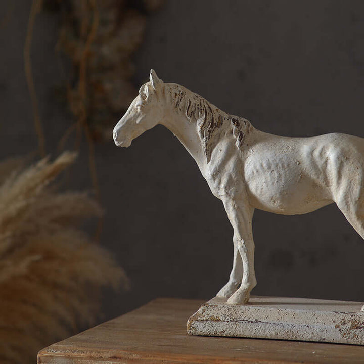 White horse statue on a wooden surface with a dark background