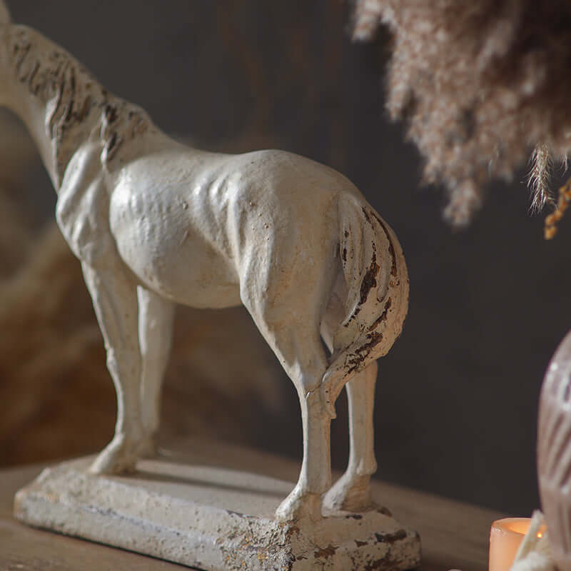 Statue of a horse on a wooden surface with a blurred background