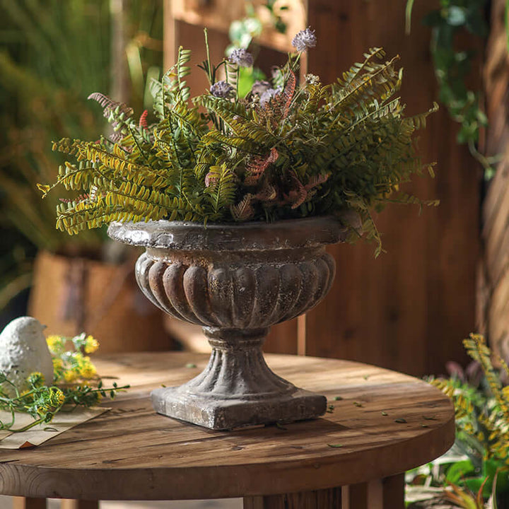 Decorative urn with plants on a wooden table
