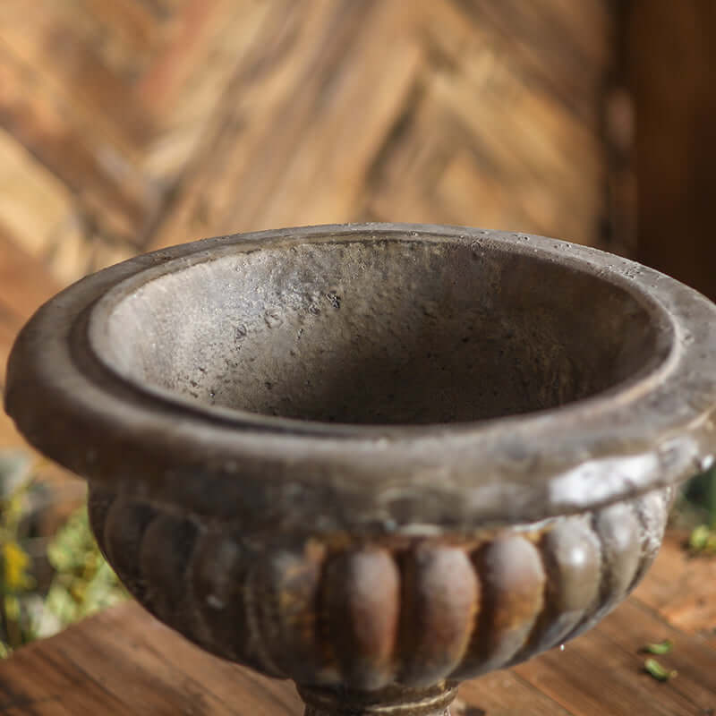 Decorative stone bowl on a wooden surface with a blurred natural background