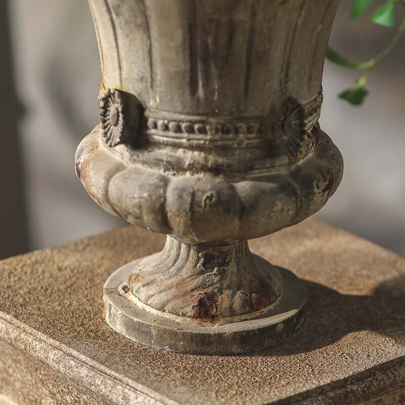 Vintage stone urn on a pedestal with a blurred background
