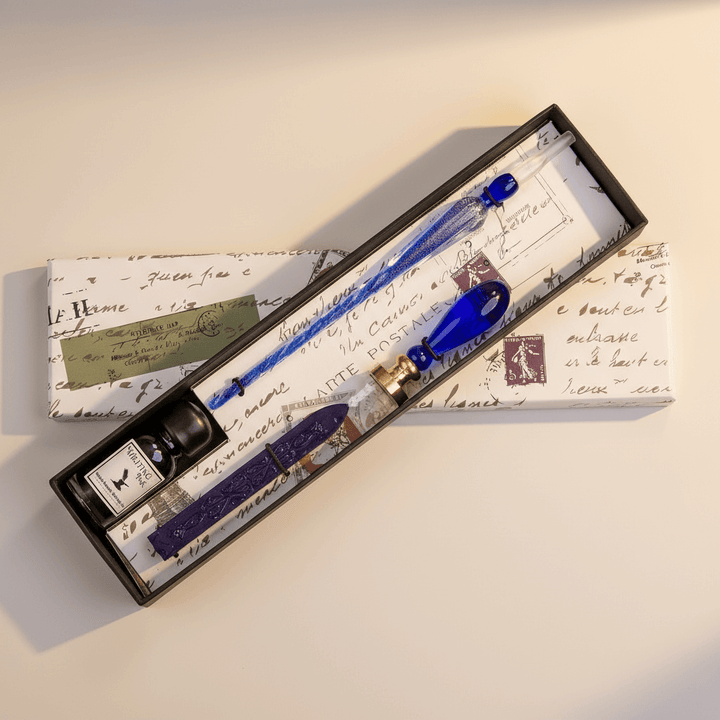Fountain pen set with blue nib and ink bottle in a decorative box on a light background