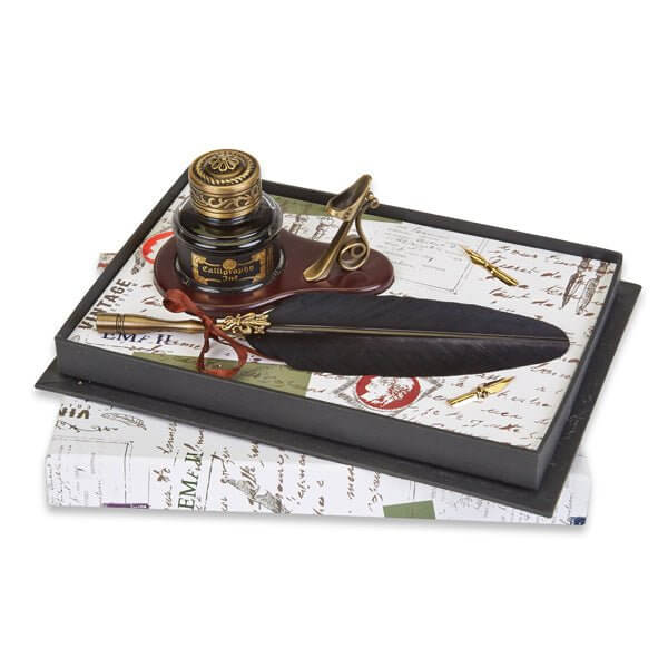 Vintage-style inkwell with feather pen on a gift box