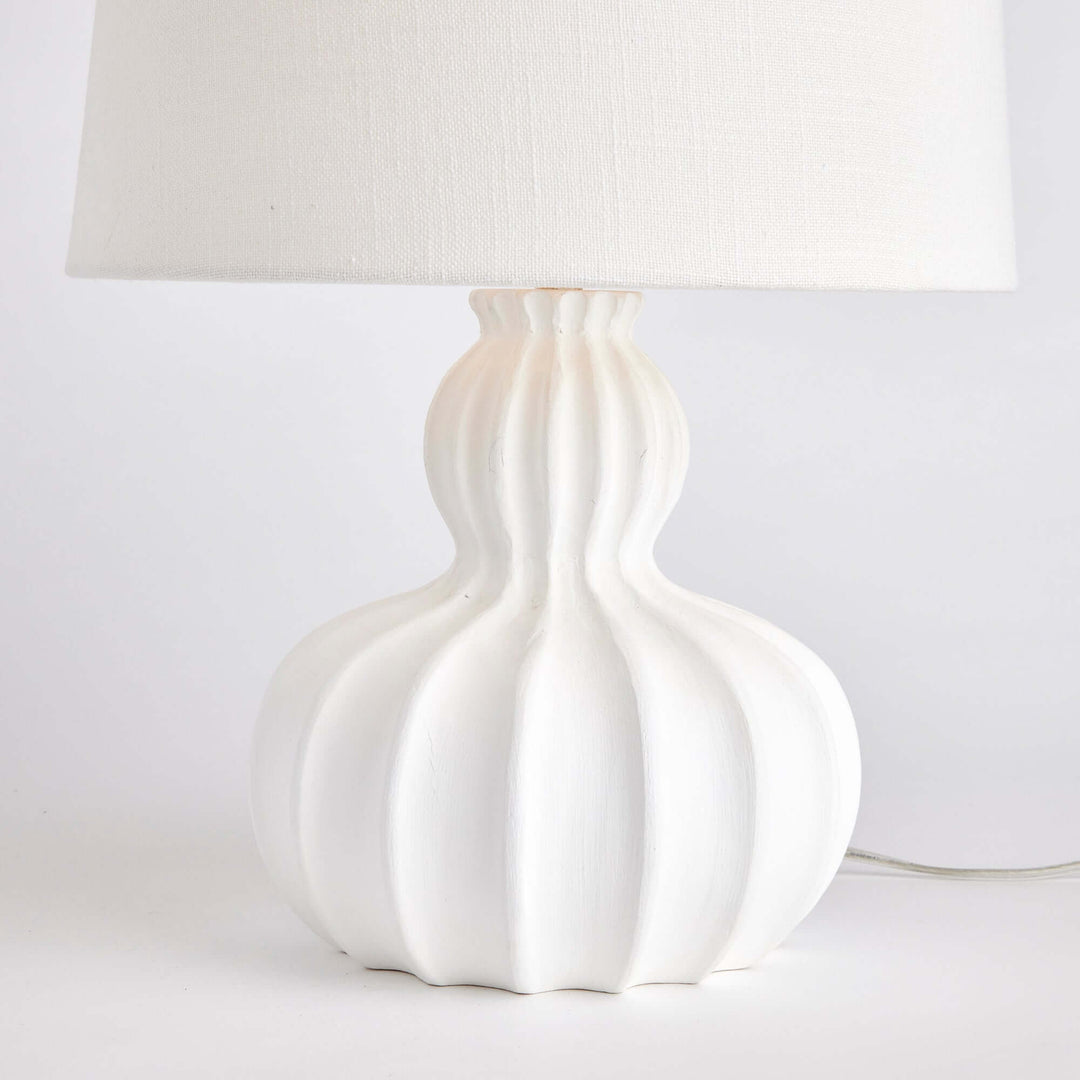 White carved wood table lamp with curved base and elegant fluted design, perfect for home decor.
