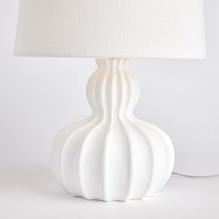 White carved wood table lamp with curved base and elegant fluted design, perfect for home decor.