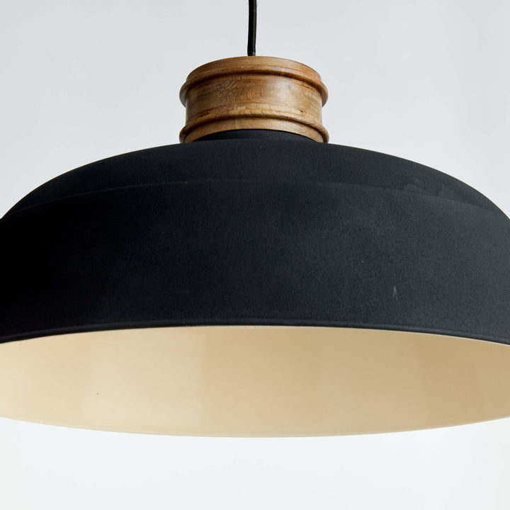 Industrial wood and metal pendant light in matte charcoal, featuring a bold black shade and warm wood neck.