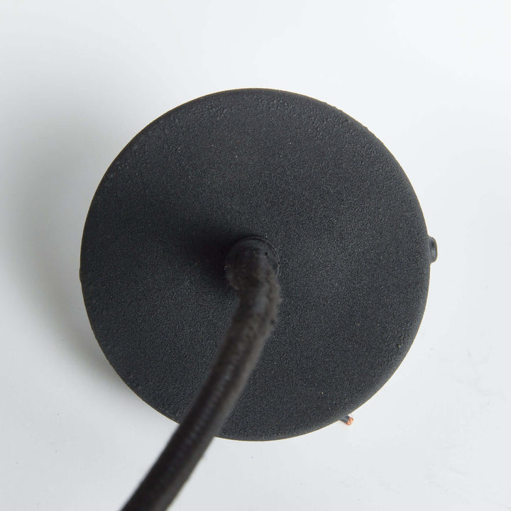Bottom view of industrial pendant light featuring matte black metal and woven cord.