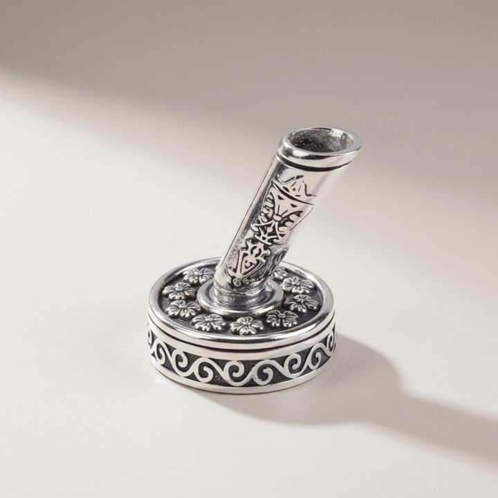 Decorative pen holder with intricate designs on a light gray background