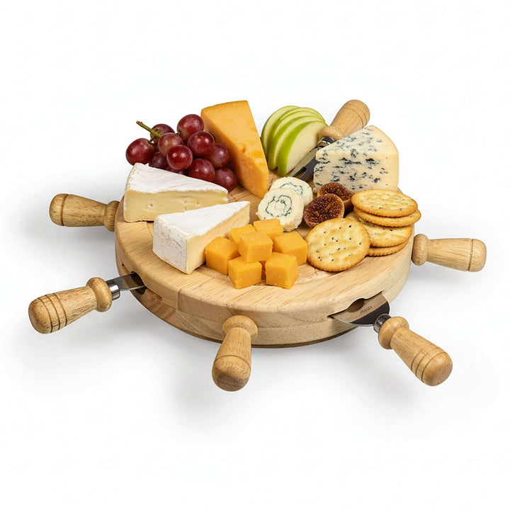 Wooden cheese board with assorted cheeses, fruits, and crackers on a white background