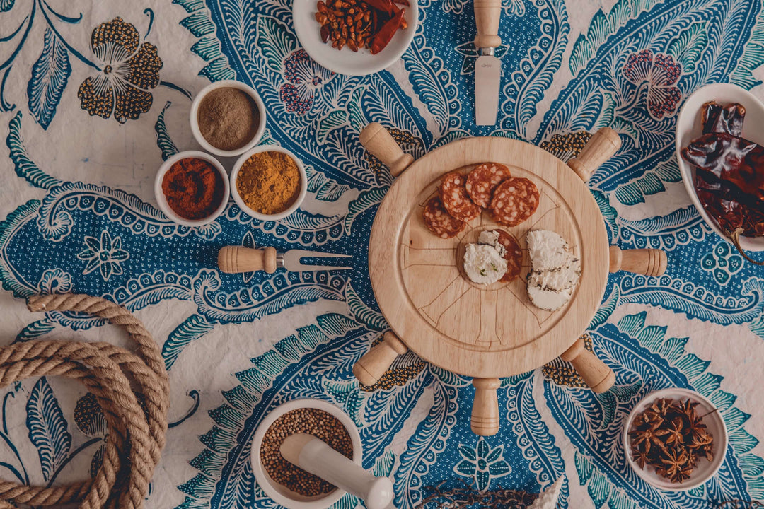 Nautical Lazy Susan Cheese Board and Knife Set on a sea-themed tablecloth with spices and rope for elegant entertaining.