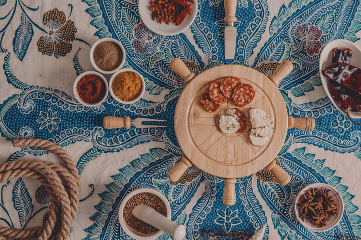 Nautical Lazy Susan Cheese Board and Knife Set on a sea-themed tablecloth with spices and rope for elegant entertaining.