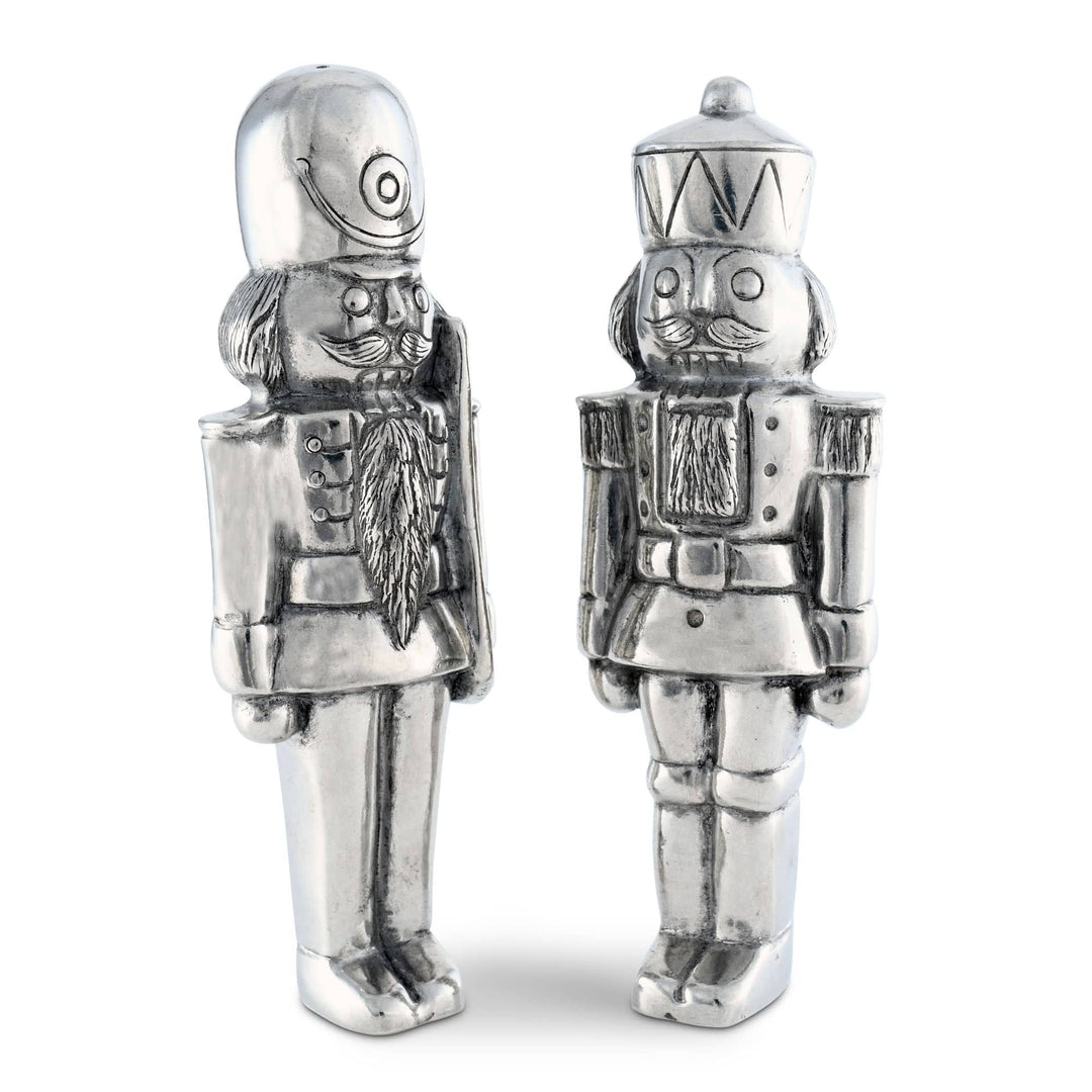 Two silver nutcracker figurines on a white background