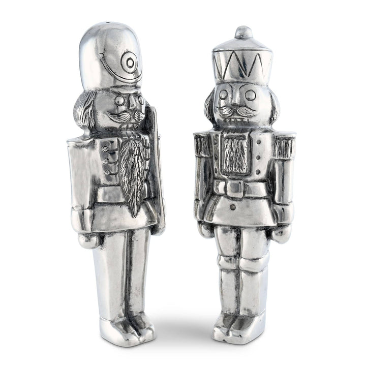 Two silver nutcracker figurines on a white background