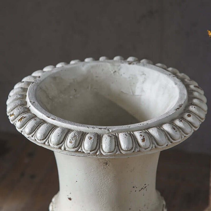 Decorative stone urn with intricate design on a blurred background