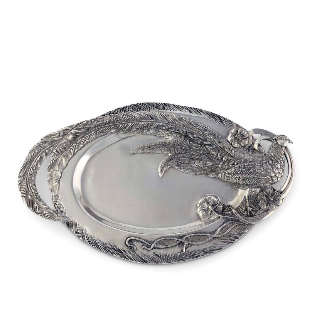 Silver decorative platter with feather and floral designs on a white background