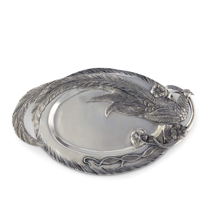 Silver decorative platter with feather and floral designs on a white background