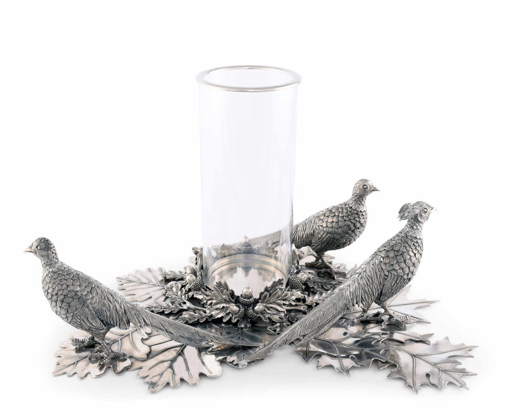 Decorative candle holder with metal bird sculptures and a glass hurricane on a white background